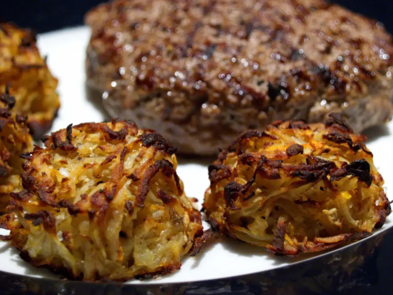 Krispiga potatisplättar serveras med en saftig köttpuck. En härlig schweizisk matupplevelse!