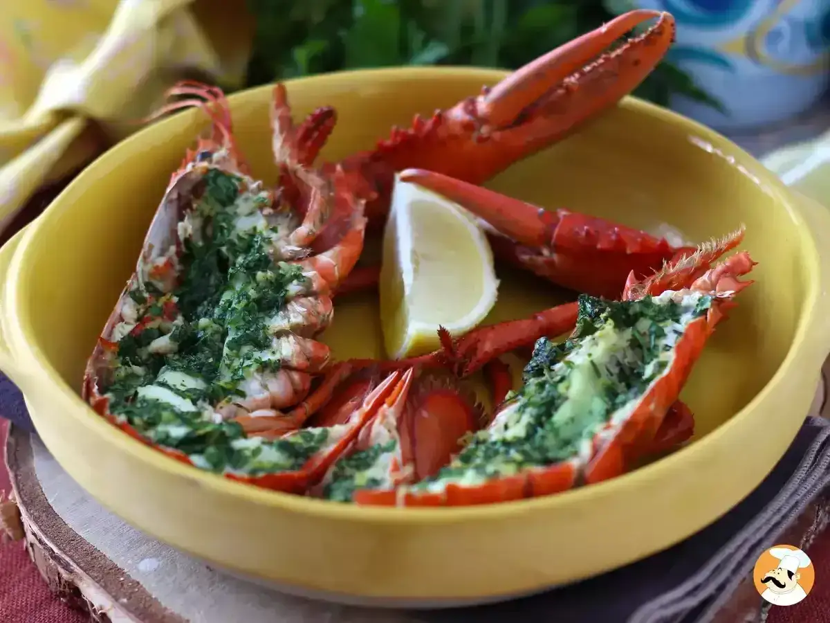 Halverad hummer gratinerad med örter, serverad med citronklyfta i gul keramikskål. Ett perfekt fine dining recept.