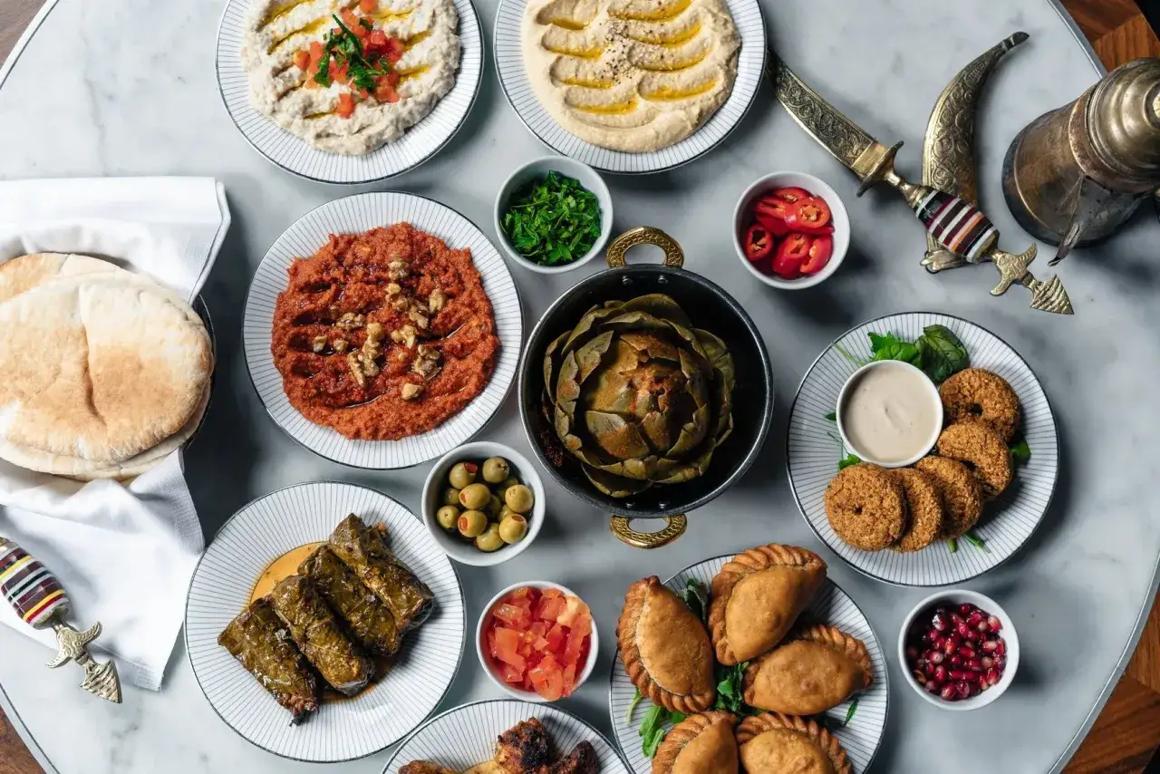 En gener&ouml;s dukning med libanesisk mat: hummus, baba ghanoush, falafel, dolmar, piroger och en hel kron&auml;rtskocka.