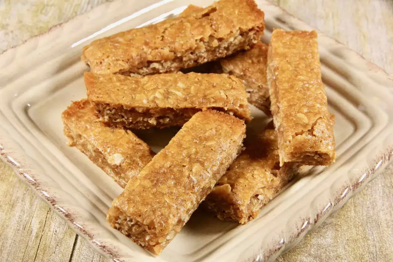 En hög med gyllene bars med havregryn och kokos, perfekta för ett snabbt mellanmål.