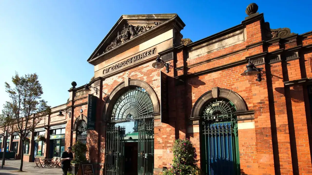 St. George's Market i Belfast, Irland. En vacker tegelbyggnad med stora valv och en skylt som visar marknadens namn.