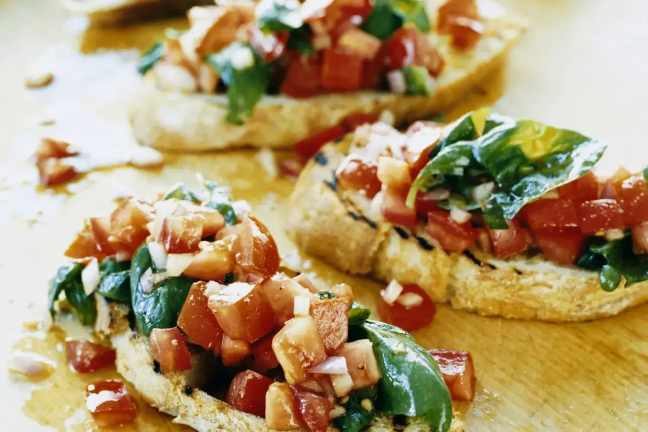Krispiga rostade brödskivor toppade med tärnad tomat, basilika och vitlök. Ett enkelt italienskt bruschetta recept som passar perfekt som förrätt.