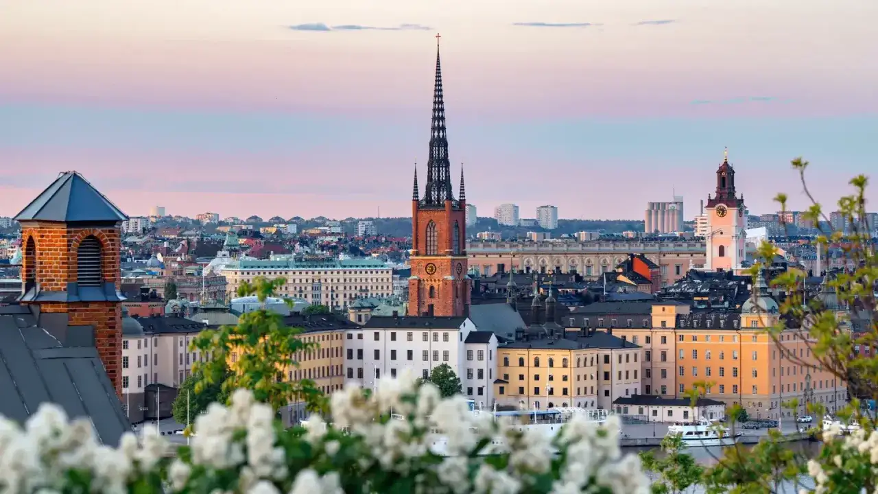 Vacker vy över Stockholms silhuett med kyrktorn och byggnader i solnedgången. Perfekt för att hitta ett bra hotell Stockholm.