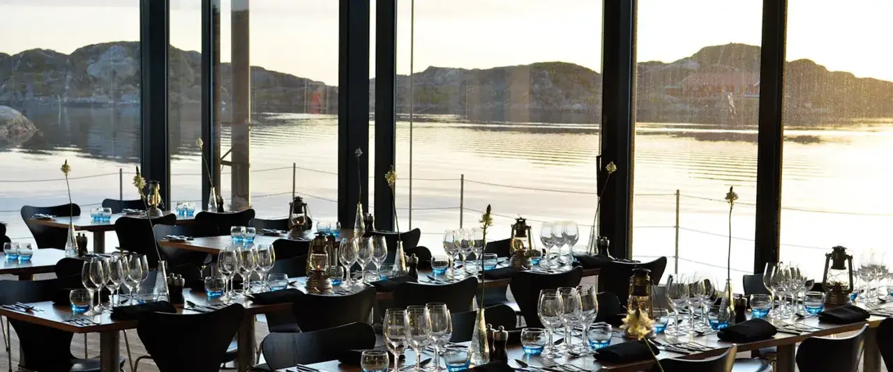 Vackert dukade bord med utsikt över skärgårdens solnedgång. Perfekt för en romantisk weekendresa Sverige.