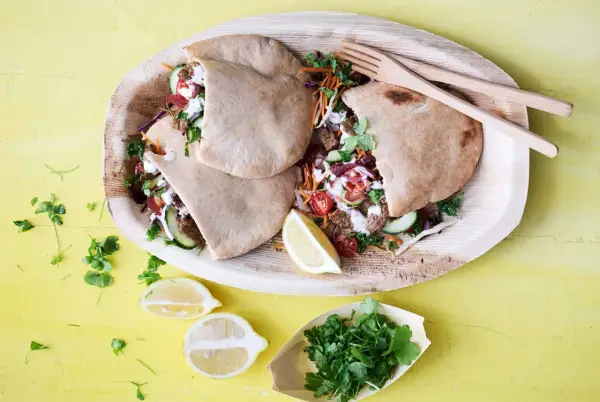 Läckra pitabröd fyllda med saftigt kött, grönsaker och en krämig sås. En härlig bit turkisk mat, serverad med citron och färska örter.