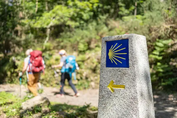 Pilgrimer på Santiago de Compostela vandring följer en sten med snäckskalssymbolen och en pil.