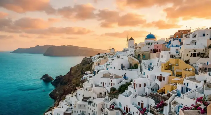 Vacker solnedgång över Oia, Santorini. Vita hus klättrar längs klippan ner mot det turkosblå havet. En dröm om en resa till Grekland.
