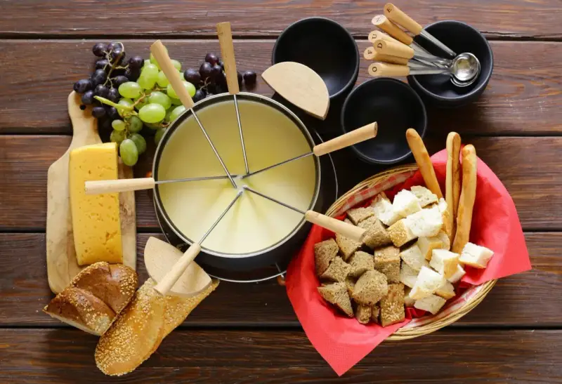 En härlig ostfondue, en klassisk schweizisk matupplevelse, med bröd, vindruvor och ost.